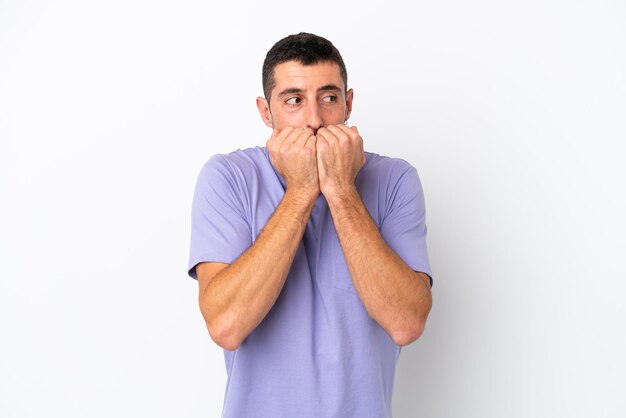 Young handsome caucasian man isolated on white background nervous and scared putting hands to mouth