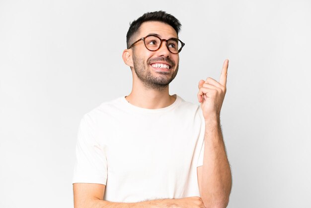 Young handsome caucasian man over isolated white background pointing up a great idea