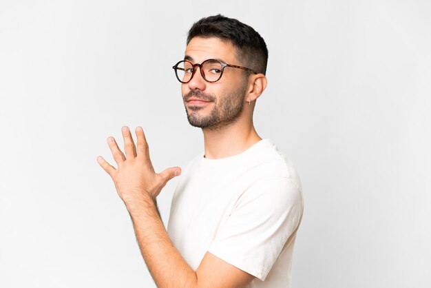 Young handsome caucasian man over isolated white background scheming something