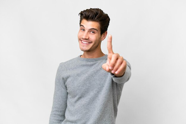 Молодой красивый кавказский мужчина на изолированном белом фоне показывает и поднимает палец