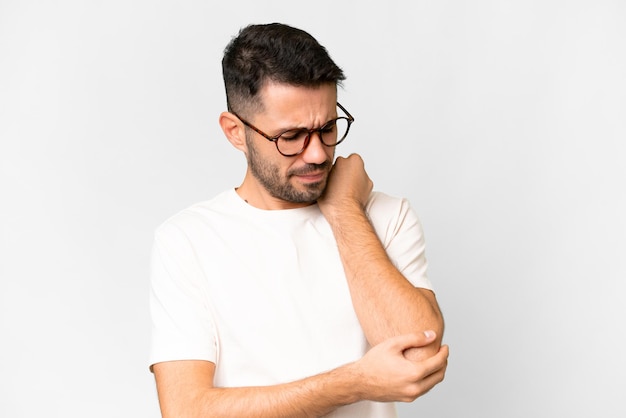 Young handsome caucasian man over isolated white background with pain in elbow