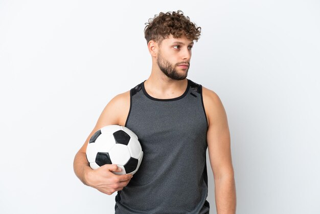 Young handsome caucasian man isolated on white background with soccer ball