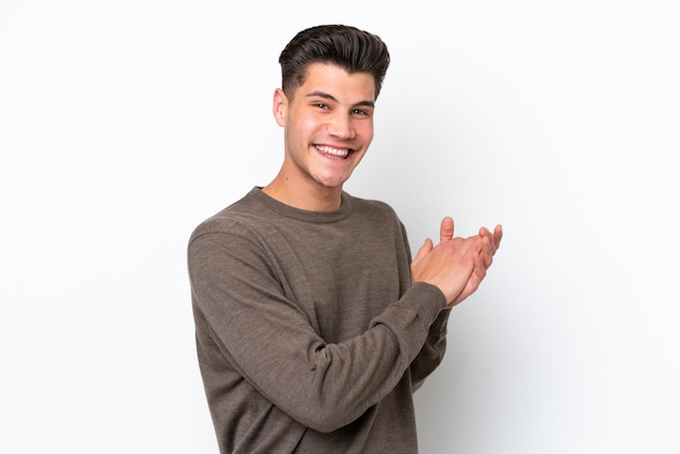 Young handsome caucasian man isolated on white bakcground applauding