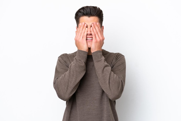 Young handsome caucasian man isolated on white bakcground covering eyes by hands