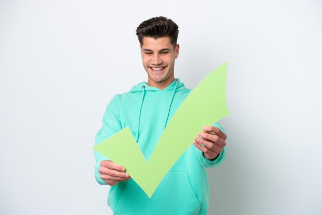 Young handsome caucasian man isolated on white bakcground holding a check icon with happy expression