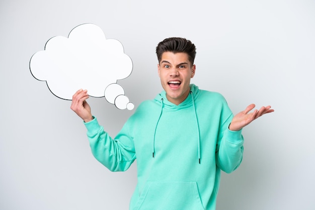 Young handsome caucasian man isolated on white bakcground holding a thinking speech bubble and with sad expression