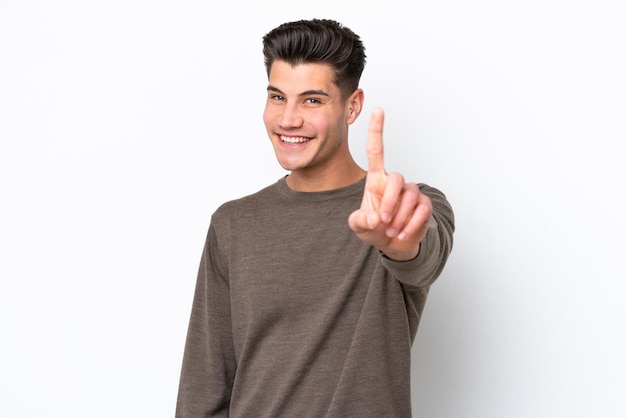 Young handsome caucasian man isolated on white bakcground showing and lifting a finger