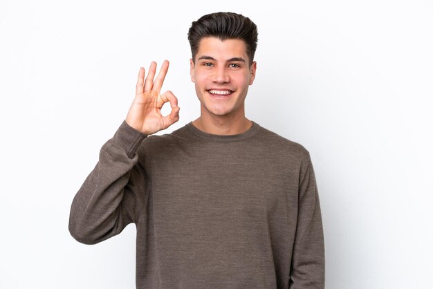 Young handsome caucasian man isolated on white bakcground showing ok sign with fingers