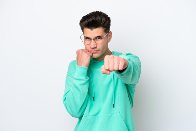 Young handsome caucasian man isolated on white bakcground with fighting gesture