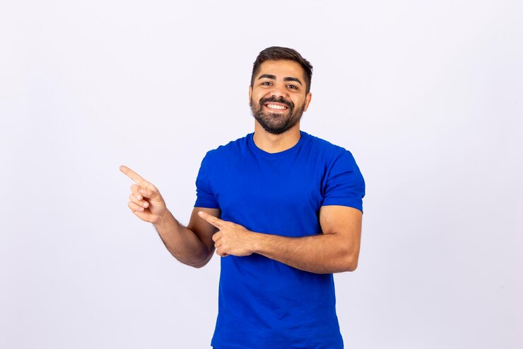 Young handsome Caucasian man pointing to free space for text