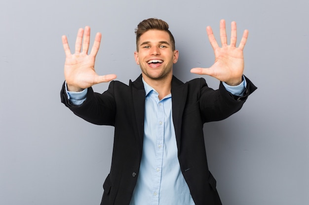 Young handsome caucasian man showing number ten with hands.