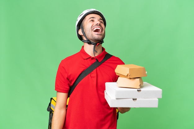 Photo young handsome caucasian man with thermal backpack and holding takeaway food