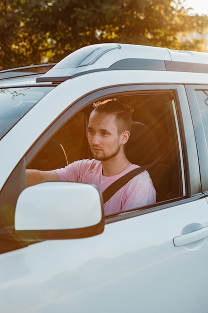 車を運転する若いハンサムな自信を持って男。ロードトリップ