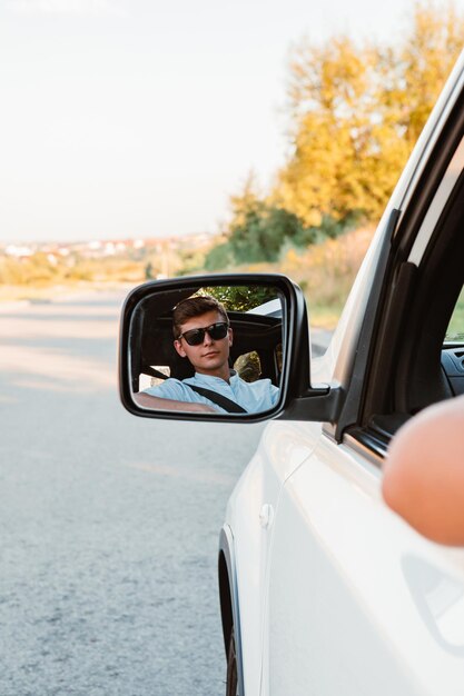 Young handsome confident man driving car