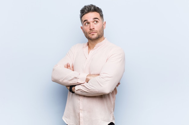 Young handsome cool man smiling confident with crossed arms.