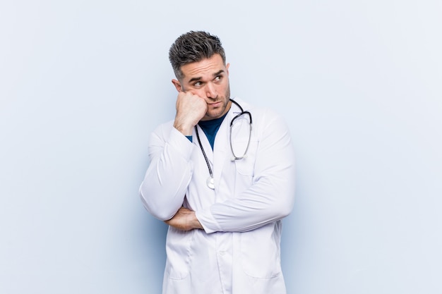 Photo young handsome doctor man who feels sad and pensive, looking at copy space.