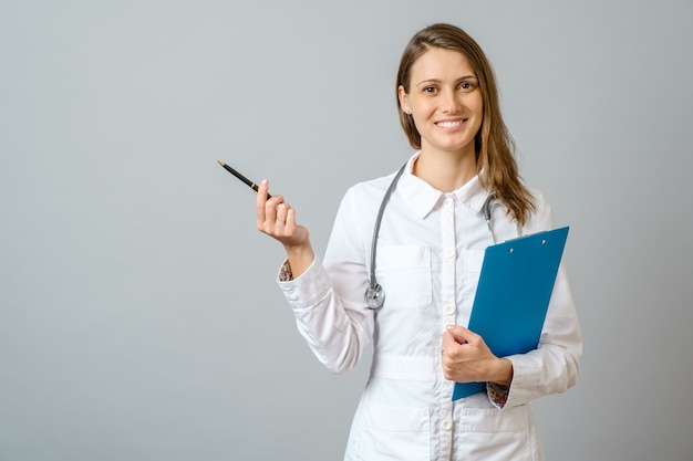 Young handsome doctor woman wearing stethoscope smiling cheerful, presenting and pointing