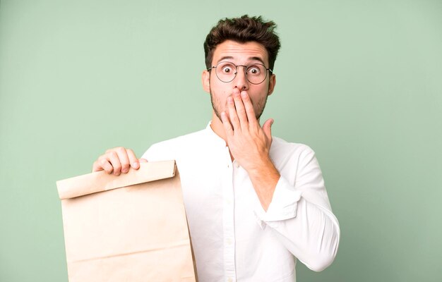 Young handsome employee man with a take away food paper bag