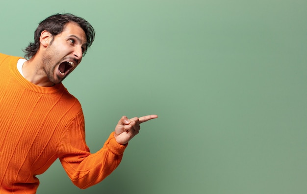 Young handsome expressive and angry indian man with a copy space