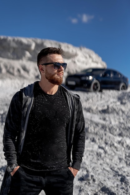 Young handsome fashionable businessman. Stylish model posing with car.