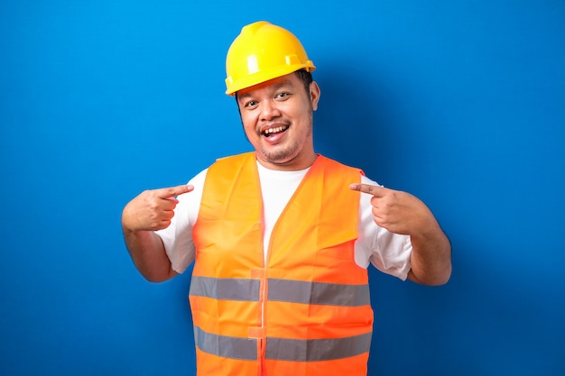 Young handsome fat asian worker man wearing orange vest and safety helmet looking confident