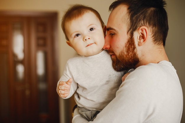 家庭で息子と遊んでいる若くてハンサムな父親