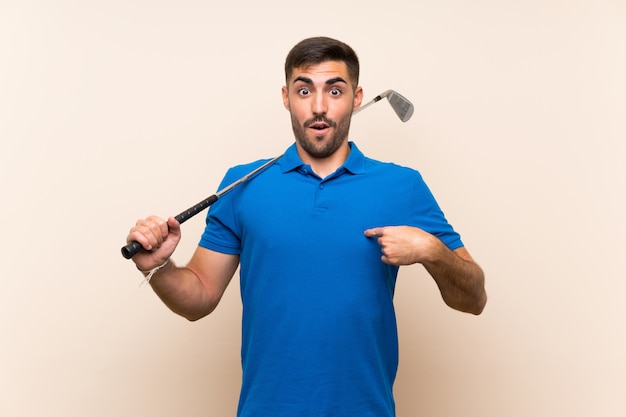 Young handsome golfer man over isolated wall with surprise facial expression