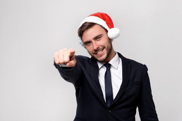 Young handsome guy in business suit and Santa hat