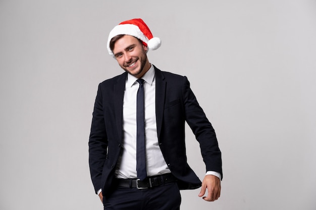 Young handsome guy in business suit and Santa hat