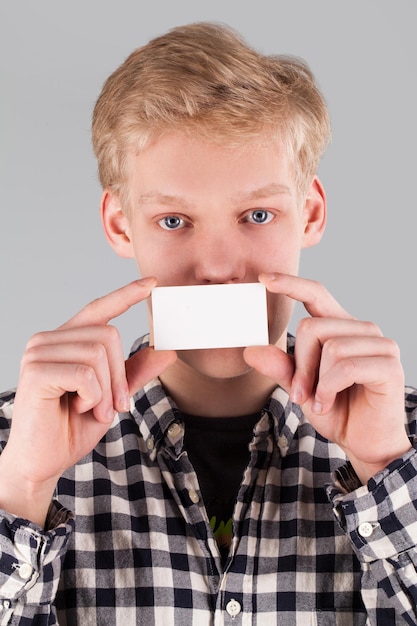 Young handsome guy holding a blank card