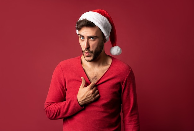 Young handsome guy in red sweater and Santa hat