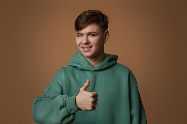 Young handsome guy in sweatshirt showing ok gesture