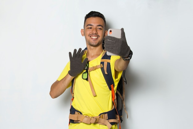 Young handsome hiker man using mobile phone isolated on white background