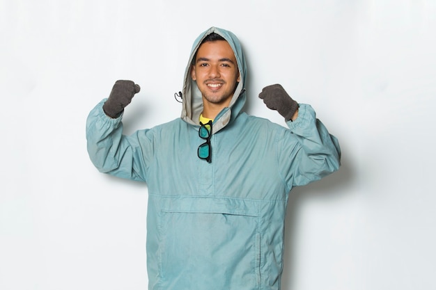 Young handsome hiker  with a backpack making strong gesture isolated on white background