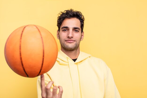 Young handsome hispanic man basketball concept