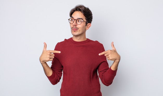 young handsome hispanic man looking proud, positive and casual pointing to chest with both hands