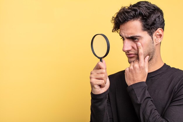 Young handsome hispanic man magnifying glass concept