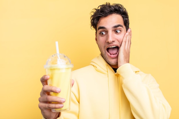 Young handsome hispanic man with a milkshake