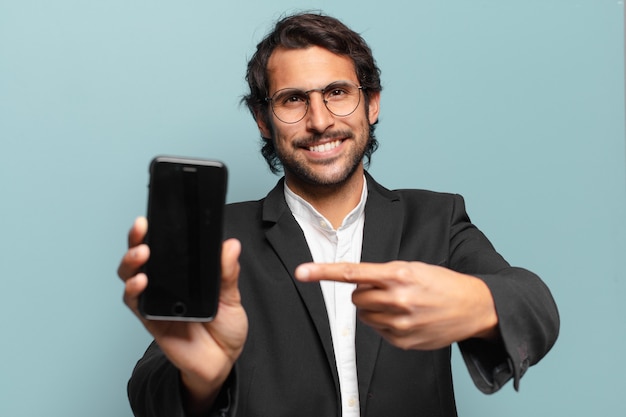 Young handsome indian businesman showing his telephone empty screen