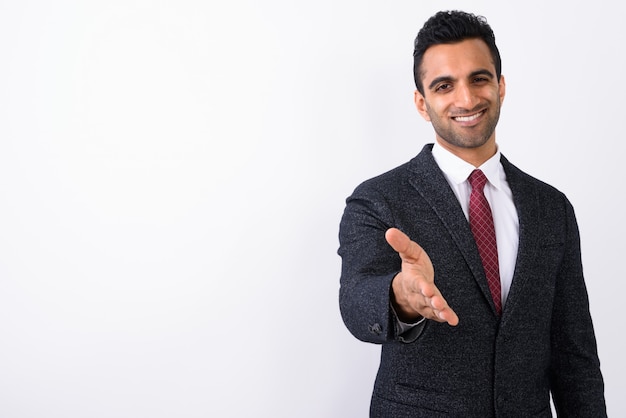 Young handsome Indian businessman against white background