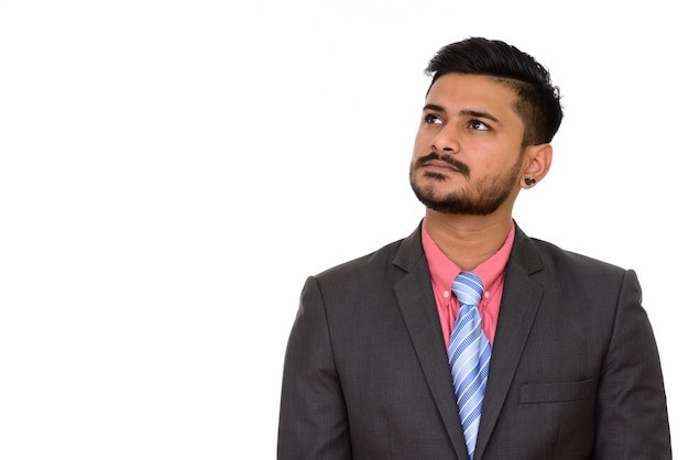 Young handsome Indian businessman thinking and looking up