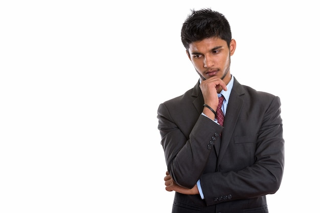 young handsome Indian businessman thinking while looking down