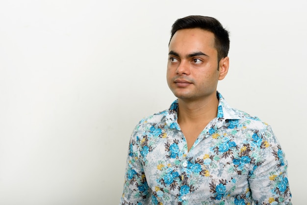 young handsome Indian hipster man against white wall