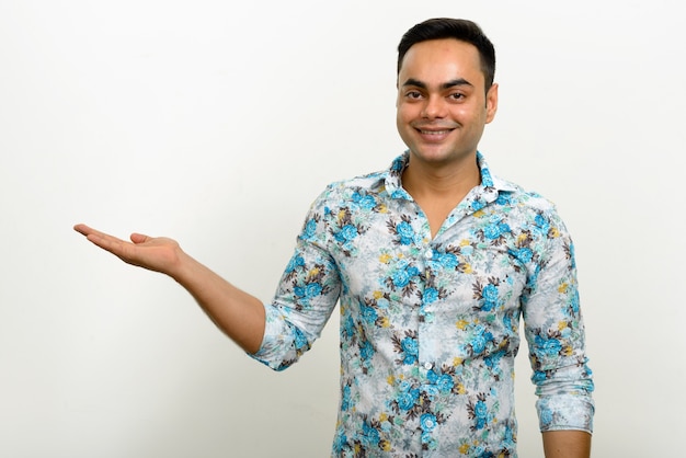 young handsome Indian hipster man against white wall