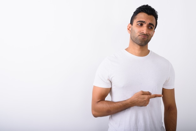 Young handsome Indian man against white background