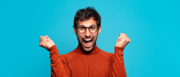 Young handsome indian man celebrating successful a victory