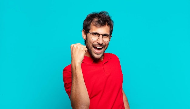 Young handsome indian man celebrating successful a victory