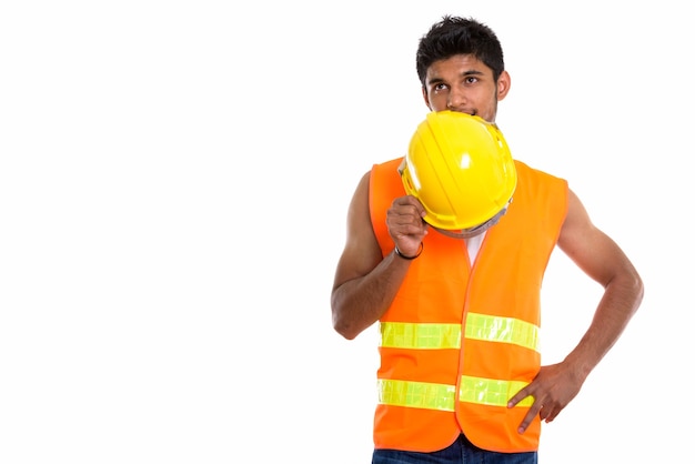 Young handsome Indian man construction worker covering face with helmet