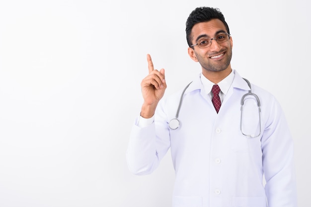 Young handsome Indian man doctor against white background