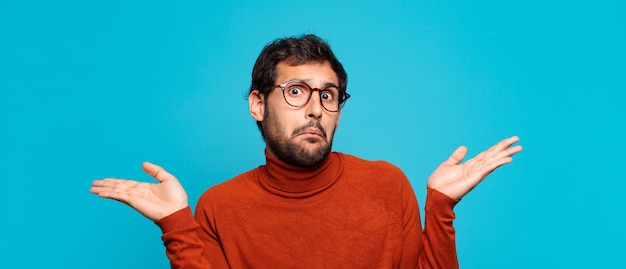 Foto giovane uomo indiano bello che dubita o espressione incerta